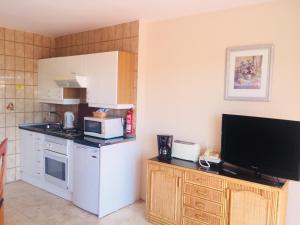 cocina pequeña con microondas y fogones en Apartamentos Coronado, en Marbella
