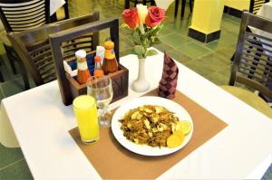 una mesa con un plato de comida y una bebida en M Hotel, en Dar es Salaam