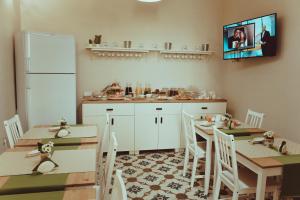 une cuisine avec des armoires et des tables blanches ainsi qu'une télévision dans l'établissement La Dimora di Teti, à Gallipoli 65 autres photos