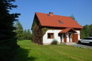 uma pequena casa branca com um telhado vermelho em Dom Na Pstrążnicy em Kudowa-Zdrój