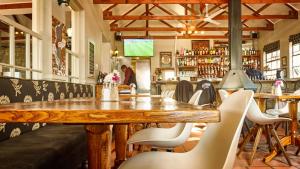 a restaurant with a large wooden table and chairs at Highland Quarters in Clarens