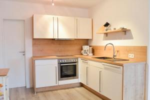 a kitchen with white cabinets and a sink at Lindenhof Hahn in Blankenrath +39 photos