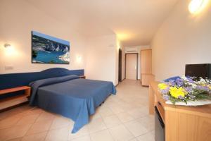 1 dormitorio con 1 cama azul y TV en Carretto Vacanze, en Peschici