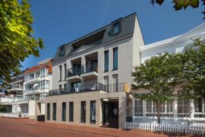 an apartment building with a balcony on a street at MeerZeit 8 - Norderney - Winterstraße 19 in Norderney