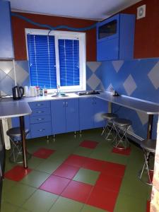 a kitchen with blue cabinets and a colorful floor at Апартаменты двухкомнатные in Kansk