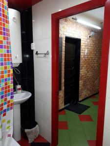 a bathroom with a red door and a bathroom with a sink at Апартаменты двухкомнатные in Kansk