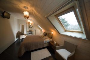 una camera mansardata con letto e finestra di B&B Artiriacumhoeve a Zedelgem