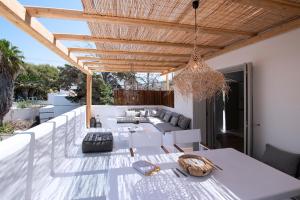a patio with a white table and a wooden ceiling at Potami Home by Rocks Estates in Naousa