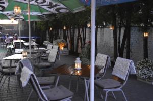 un patio con mesas y sillas bajo una sombrilla en Hotel Ajax, en Janki