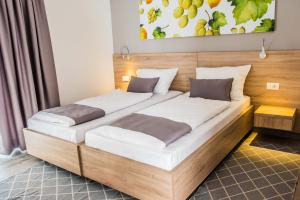 two beds in a hotel room with a wooden headboard at FoRest Međugorje in Međugorje