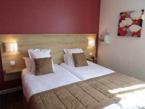 1 dormitorio con 1 cama grande con sábanas y almohadas blancas en Le Pavillon de Rouen, en Franqueville-Saint-Pierre