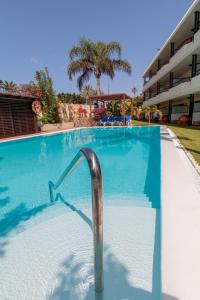 a swimming pool with a hand rail in a resort at VIP Apartamentos Nogal- Adults Only in Playa del Ingles