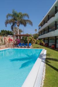 a swimming pool in front of a building at VIP Apartamentos Nogal- Adults Only in Playa del Ingles