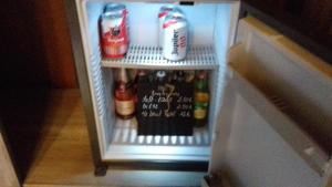een open koelkast met drankjes en frisdranken. bij Les chambres de la Cour in Arsimont