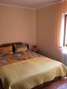 a bedroom with a bed with a yellow comforter and a window at Sea Blue Apartament City Park Mall in Constanţa