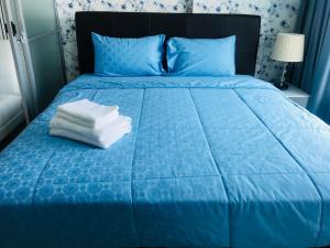 a blue bed with blue sheets and towels on it at บ้านเพียงเพลิน in Hua Hin