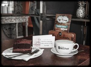 a table with a piece of cake and a cup of coffee at Bacchus Hotel in Sutton on Sea