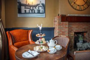 a table with two chairs and a tea set on it at Bacchus Hotel in Sutton on Sea