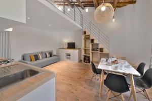 a kitchen and a living room with a table and chairs at Sarpi Loft Florence in Florence