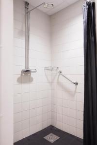 uma casa de banho com um chuveiro com uma cortina de chuveiro preta em Kom Family em Estocolmo