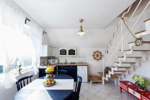 a kitchen and dining room with a table and a staircase at Family Garden Apartmanház in Siófok