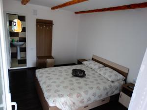 a bedroom with a bed with a hat on it at Casa Veche Corbeni in Corbeni