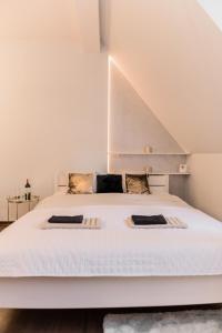 a bedroom with a large white bed with two pillows at GoldenEye Apartment Center in Wrocław