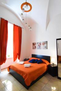 1 dormitorio con cama con sábanas de color naranja y ventana en Sunrise B&B, en Nápoles