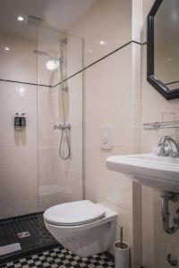 ベルリンにあるアンリ ホテル ベルリン クアフュルステンダムのバスルーム(シャワー、トイレ、シンク付)