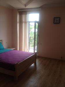 a bedroom with a bed and a large window at Nodari in Batumi
