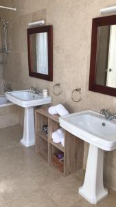 uma casa de banho com 2 lavatórios, uma banheira e um espelho. em Marchanta em Santarém