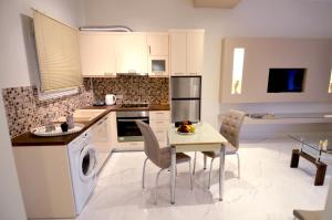 a kitchen with a table and chairs in a kitchen at Stefanos Resort in Mesongi