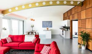a living room with a red couch and a table at Amazing beach apartment in Lancing