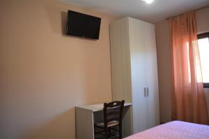 a bedroom with a desk and a television on the wall at Spazio Natura in Castelmezzano