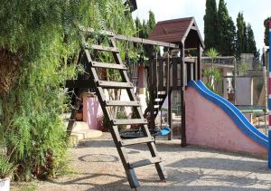 una escalera de madera en un parque infantil con tobogán en Finca Doña Sofia Maria, en San Pedro del Pinatar