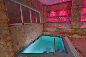 una piscina in una stanza con un muro in pietra di Hotel Terme Saint Raphael a Ischia