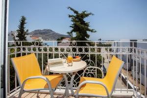 un tavolo e sedie su un balcone con vista di Porto Plakias & Spa a Plakiás