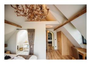 ゼデルヘムにあるB&B A'Laiseのベッド1台、シャンデリア付きの天井が備わる客室です。