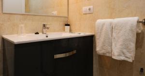 a bathroom with a white sink and a mirror at dp85 Apartamentos in Sarria