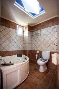 普拉基亞斯的住宿－Porto Plakias & Spa，带浴缸、卫生间和天窗的浴室