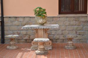 Villa Tiberio في San Mauro Castelverde: طاولة حجرية عليها مزهرية