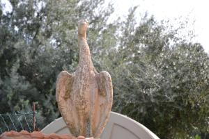 Una statua di un uccello che sta sopra un tetto di Villa Tiberio a San Mauro Castelverde