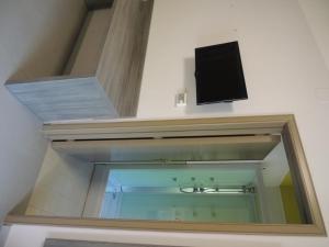 La salle de bains est pourvue d'un miroir et d'une télévision murale. dans l'établissement Camping Zeus, à Pompéi