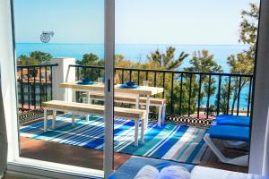 einen Balkon mit einem Tisch und Meerblick in der Unterkunft PEDREGALEJO SUN & RELAX in Málaga