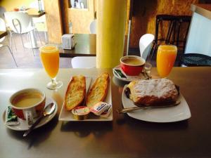 una mesa con dos platos de comida y dos vasos de zumo de naranja en Pension Segura, en Murcia