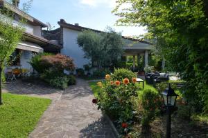 une maison avec un jardin fleuri et un chemin dans l'établissement Casa Maria, à Manerba del Garda