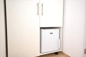 a refrigerator in a kitchen with white cabinets at Villa Doris in Neum