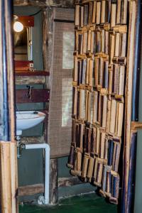 uma casa de banho com um monte de livros na parede em Epupa Falls Lodge em Epupa