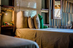 um quarto com uma cama com almofadas e uma janela em Epupa Falls Lodge em Epupa