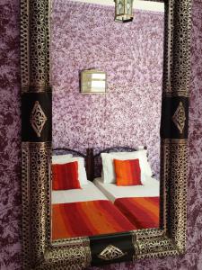 espejo reflejo de un dormitorio con cama en Les Tajines Bleus en Tamanar